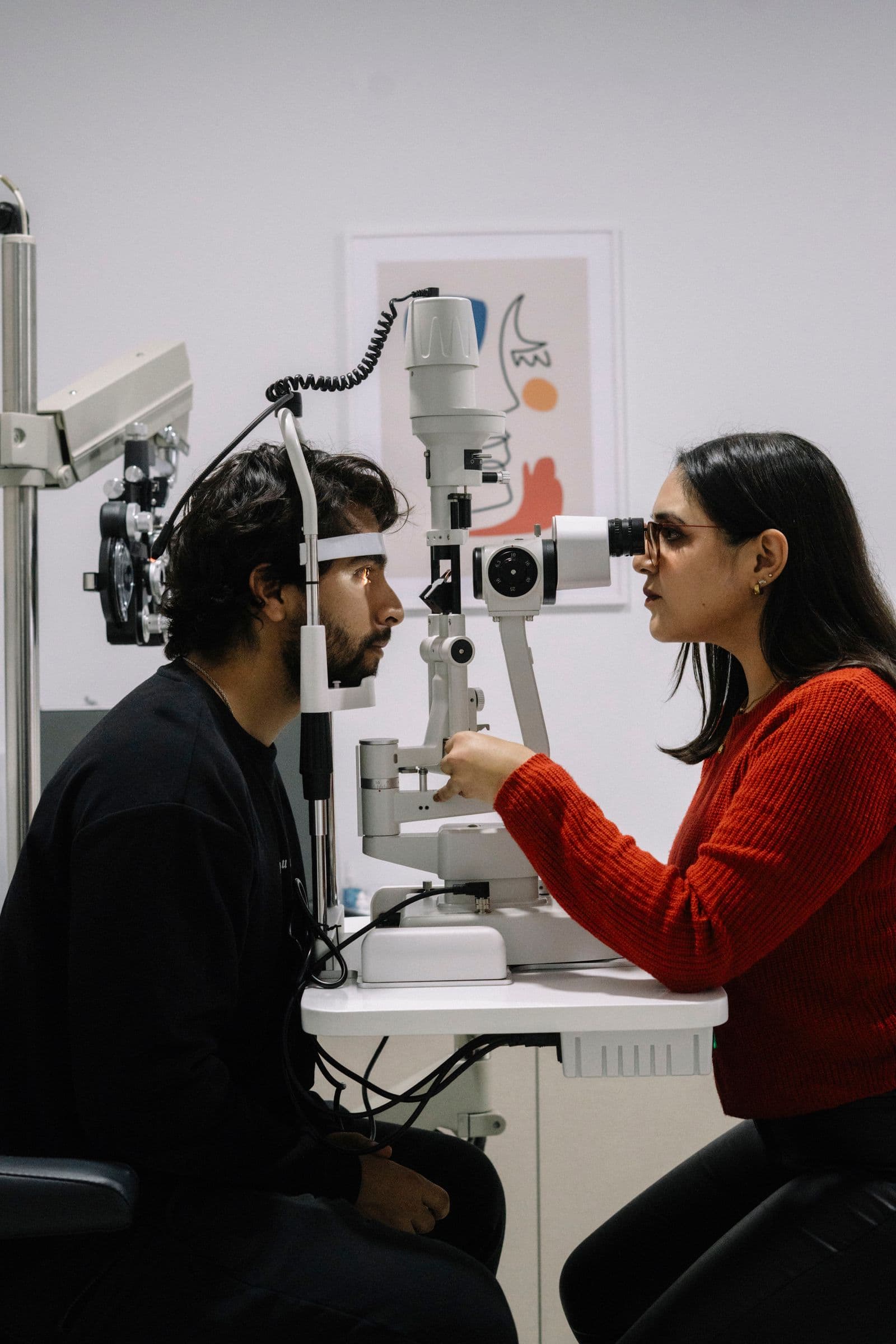 Optometrist examining a patient's eyes with a slit lamp